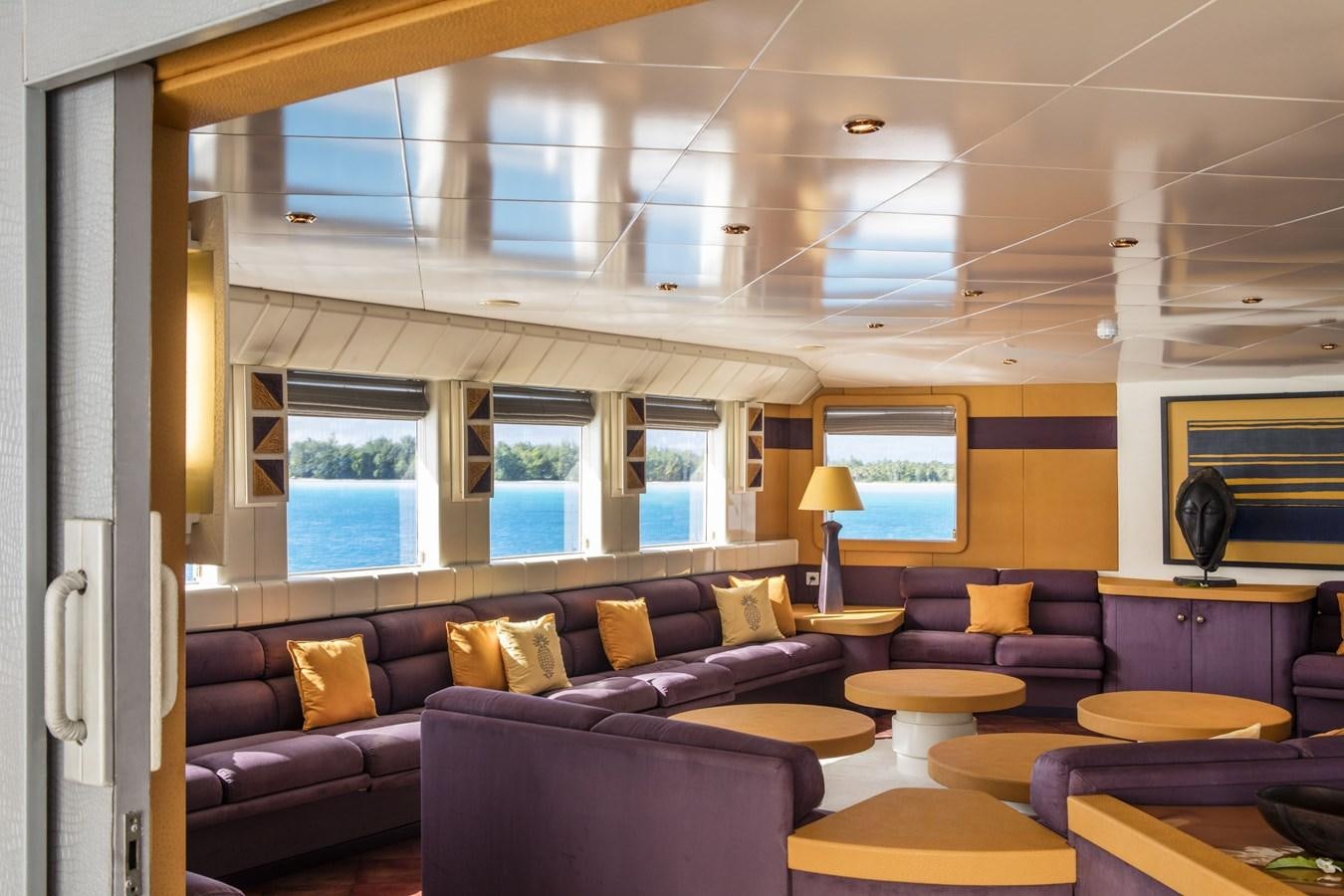 a living room with a couch and a window aboard HAUMANA Yacht for Sale