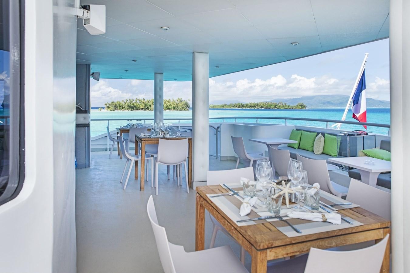 a table set for a meal on a balcony aboard HAUMANA Yacht for Sale