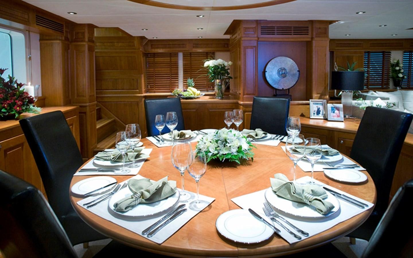 a dining room table with plates and chairs aboard SUNNY HILL Yacht for Sale