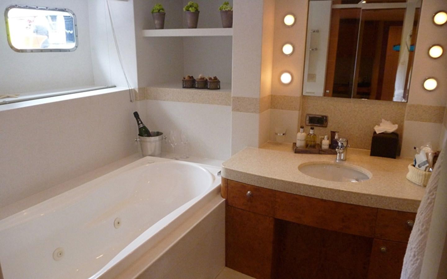 a bathroom with a tub sink and a mirror aboard SUNNY HILL Yacht for Sale