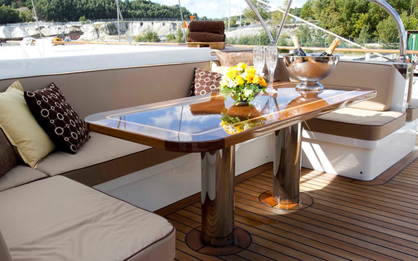 a table with a glass bowl and a couch with pillows on it aboard SUNNY HILL Yacht for Sale