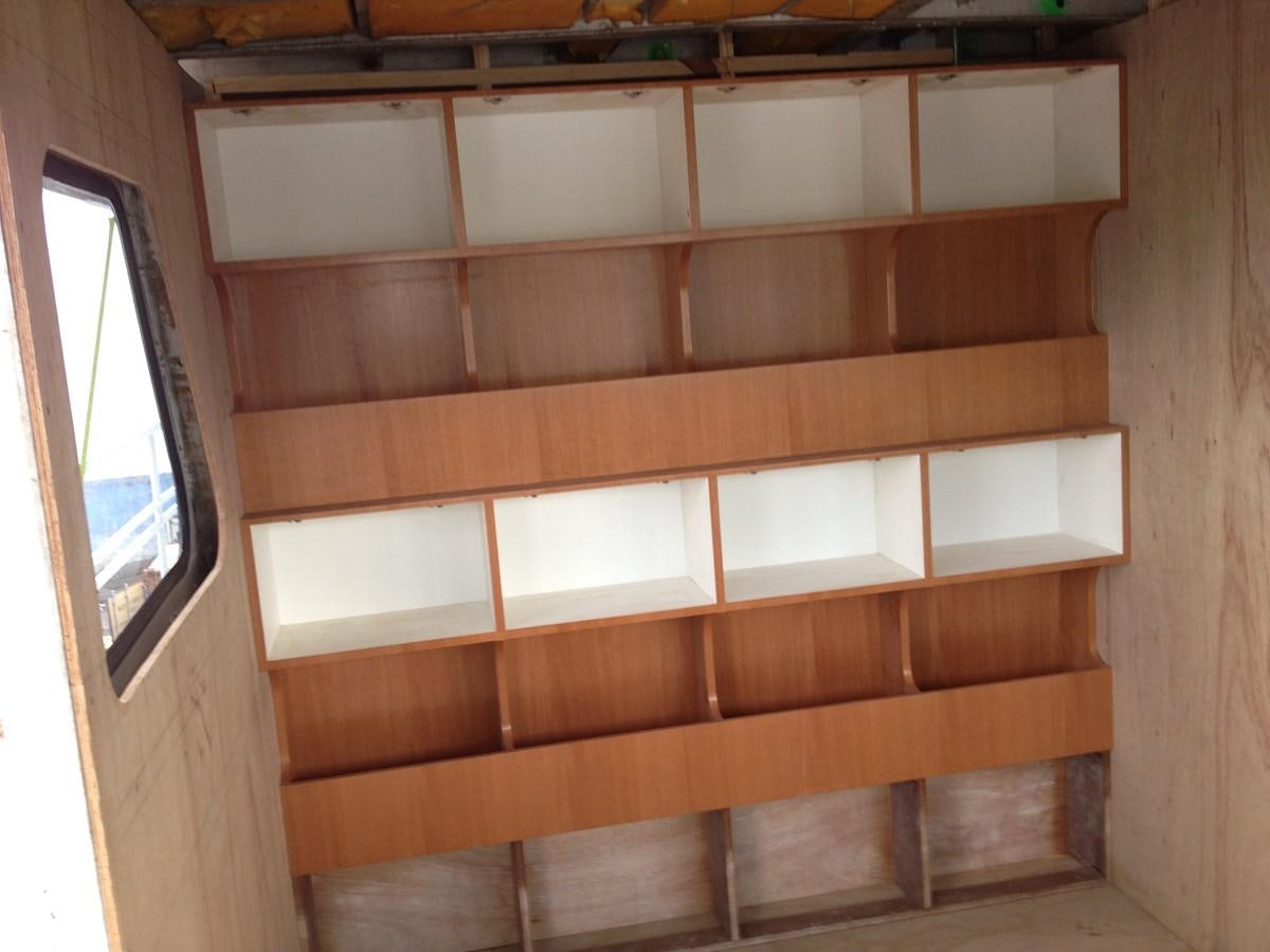 a wooden shelf with white drawers aboard CALLISTO Yacht for Sale
