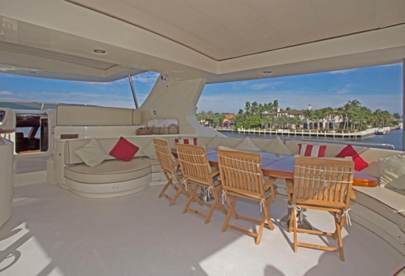 a table and chairs on a patio aboard MOMENTO.   2006 AZIMUT 116 @ Yacht for Sale