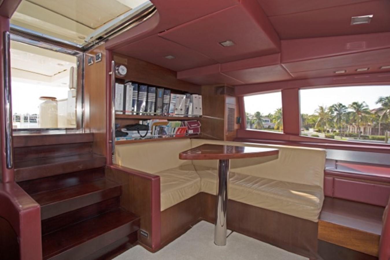 a room with a table and bookshelves aboard MOMENTO.   2006 AZIMUT 116 @ Yacht for Sale