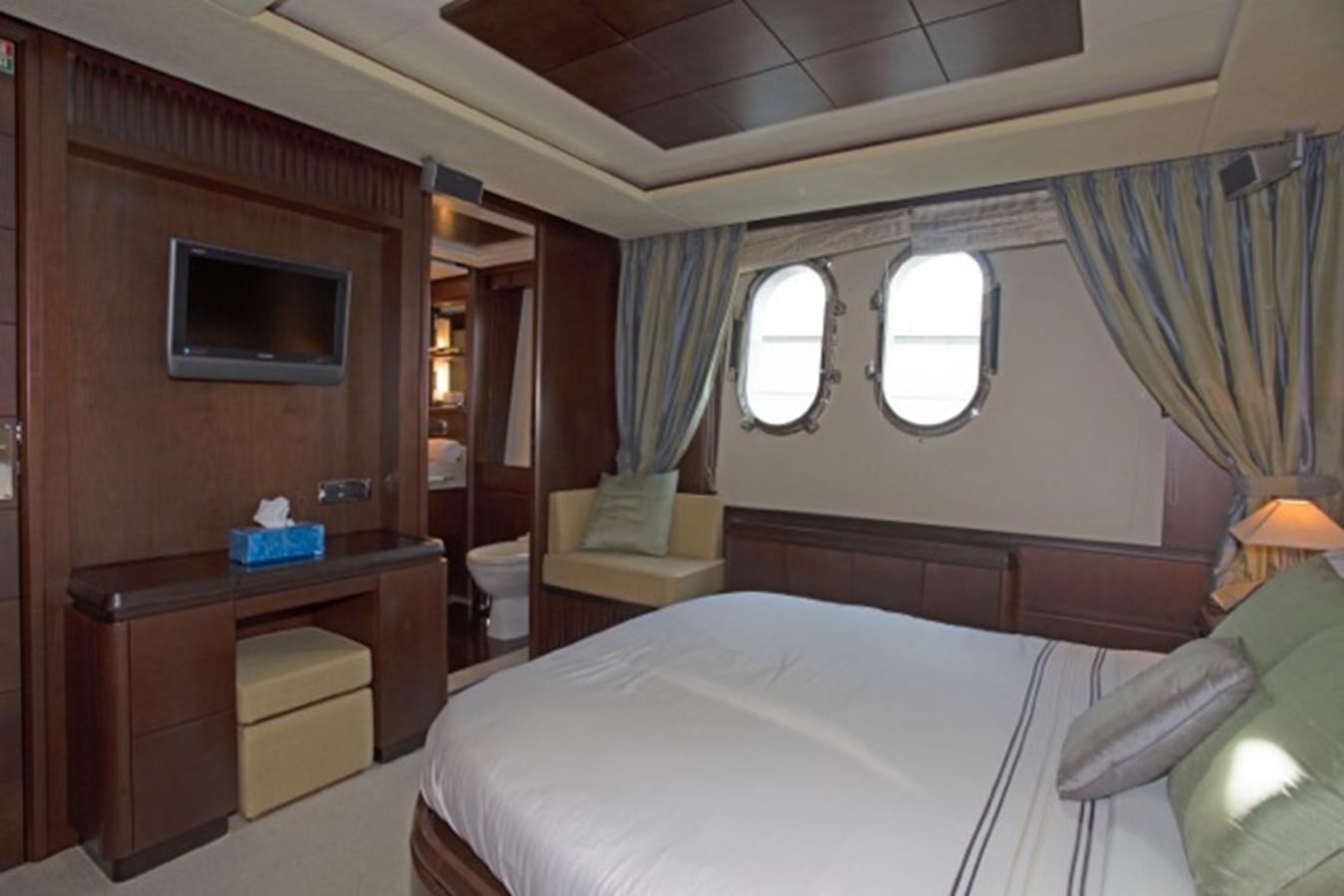 a room with a bed and a television aboard MOMENTO.   2006 AZIMUT 116 @ Yacht for Sale