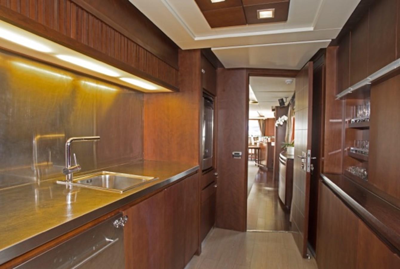 a kitchen with wooden cabinets aboard MOMENTO.   2006 AZIMUT 116 @ Yacht for Sale