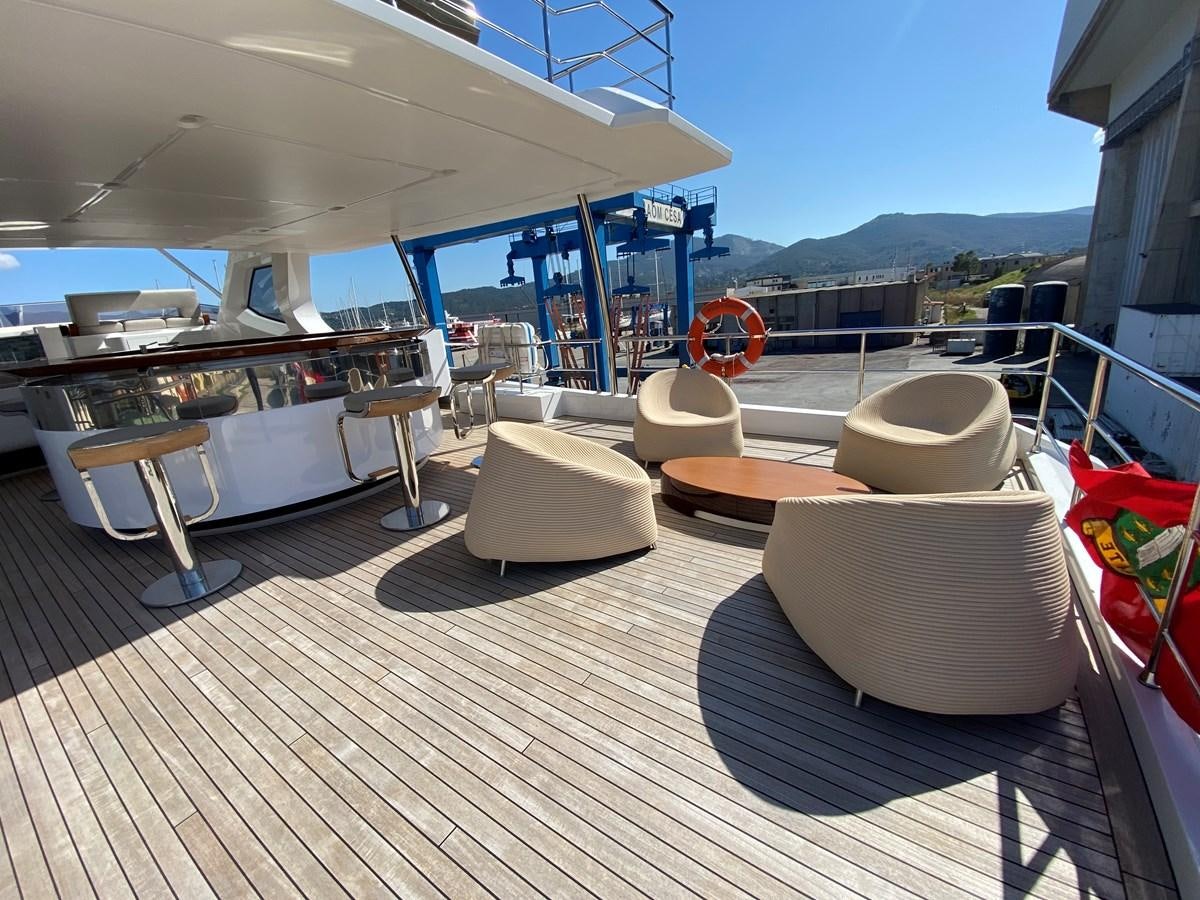 a deck with a view of the ocean and mountains aboard PARTNER Yacht for Sale