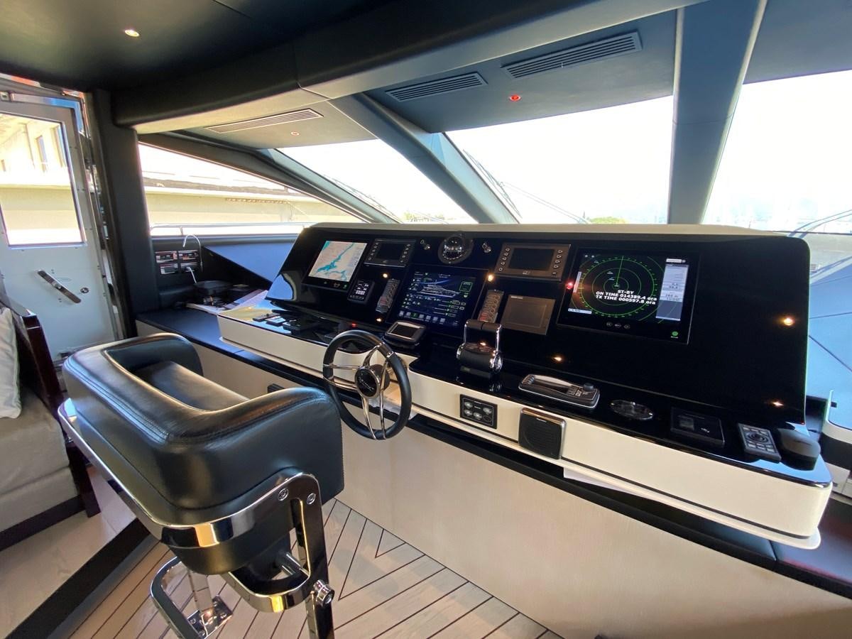 a large black console with a chair and a chair in a room with a window aboard PARTNER Yacht for Sale