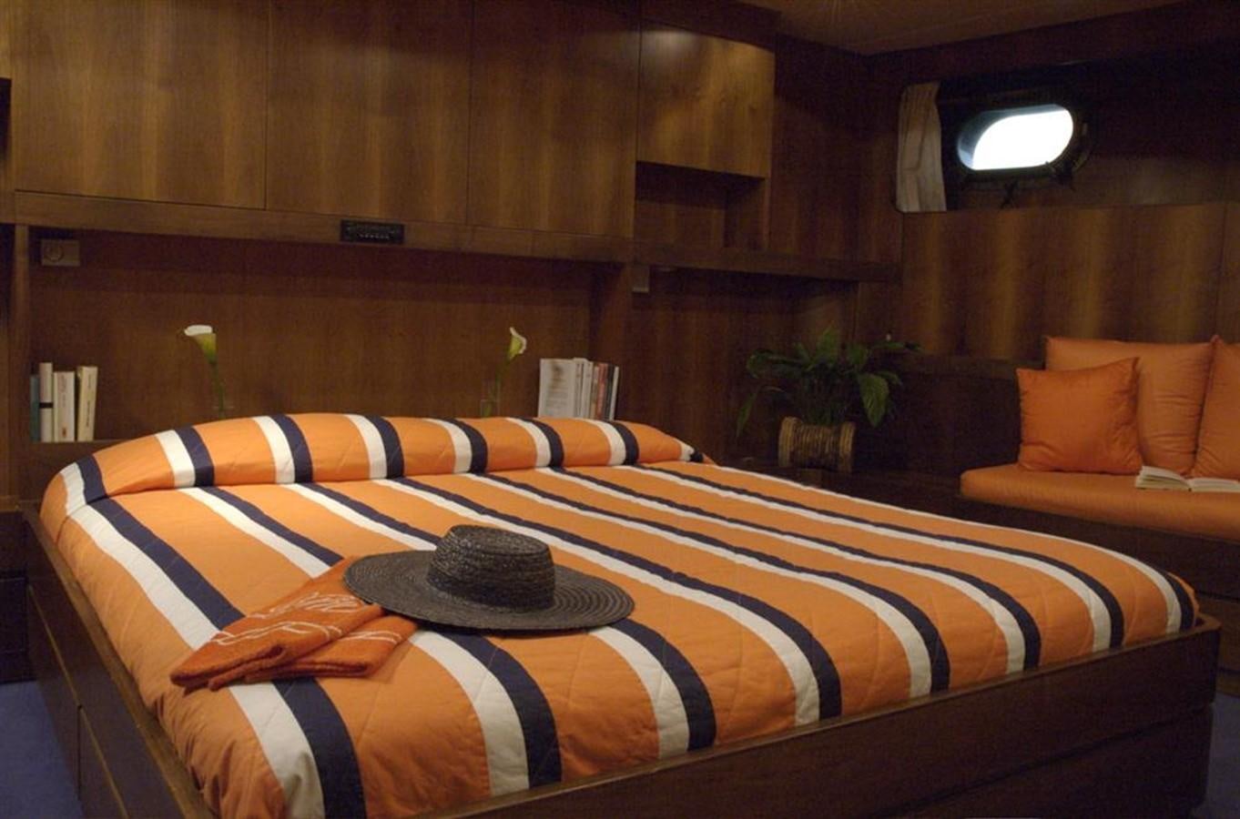 a bed with a colorful comforter aboard BARCABLU Yacht for Sale