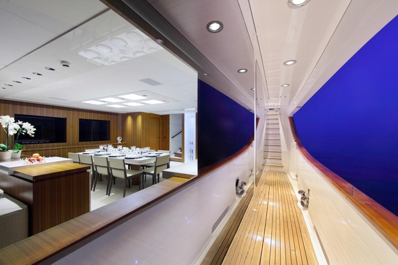 a long wooden hallway with tables and chairs aboard SEA SHELL Yacht for Sale