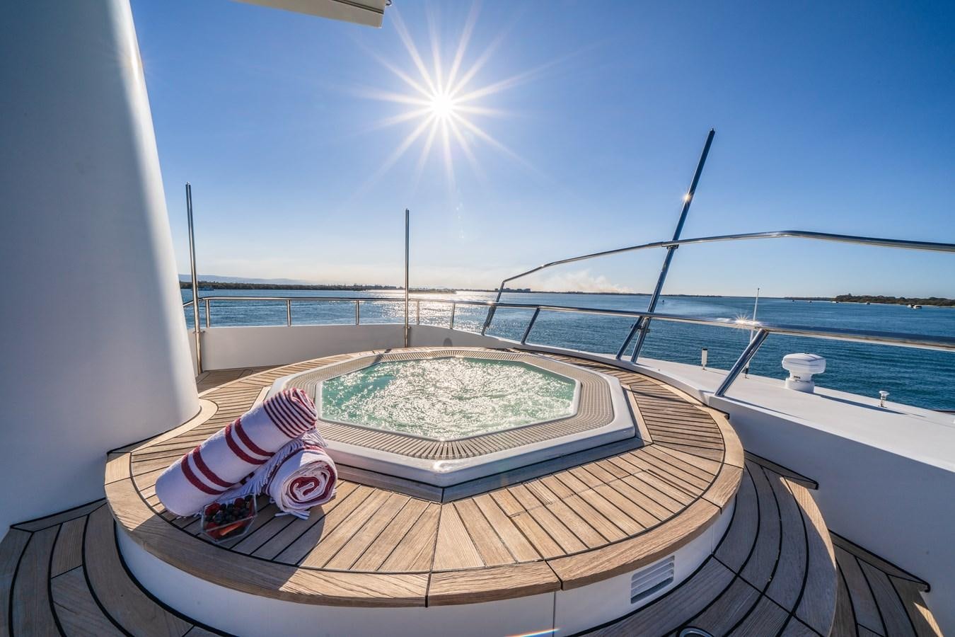 a deck with a table and chairs on it and a body of water in the background aboard RELENTLESS Yacht for Sale