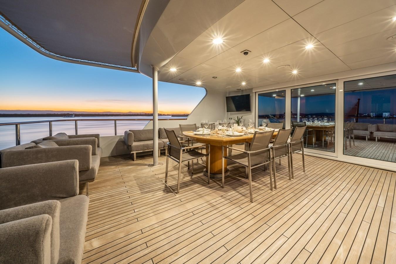 a large room with a table and chairs and a large pool aboard RELENTLESS Yacht for Sale