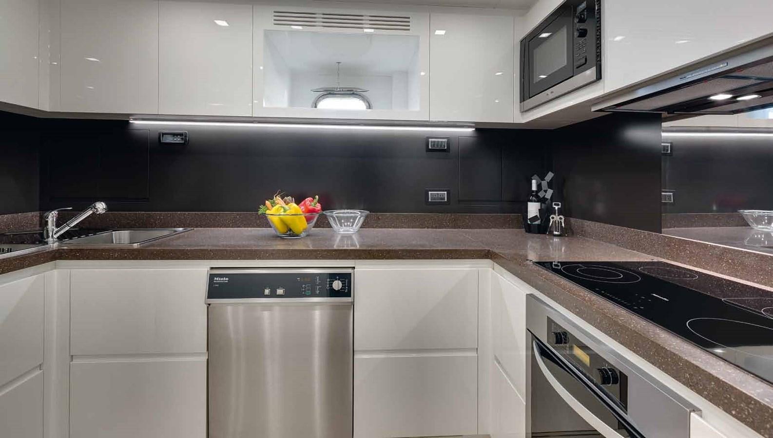 a kitchen with white cabinets aboard AXTANA Yacht for Sale