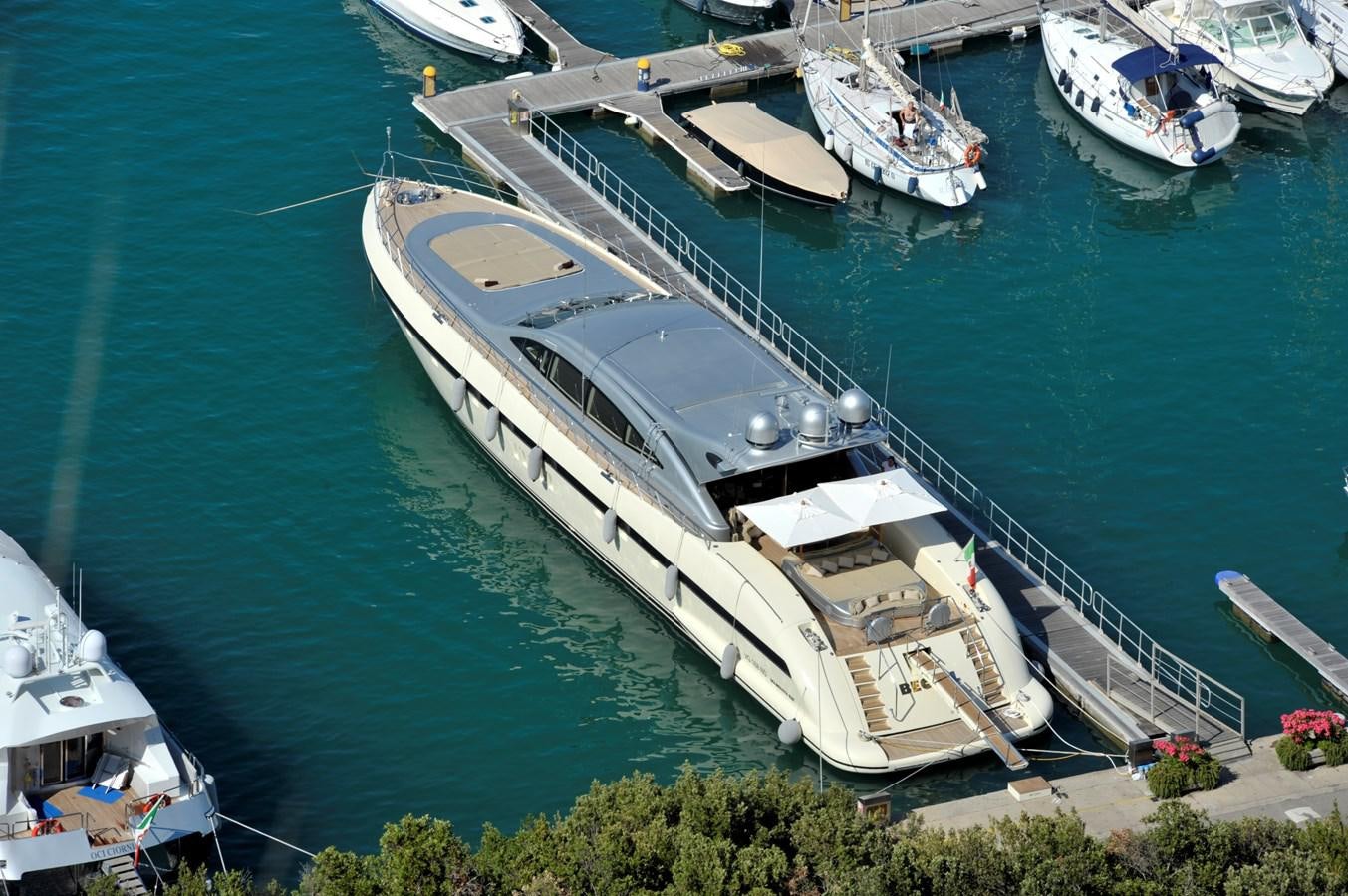 a large boat docked at a pier aboard MANGUSTA 108 - BECOOL - CAREFULLY USED Yacht for Sale