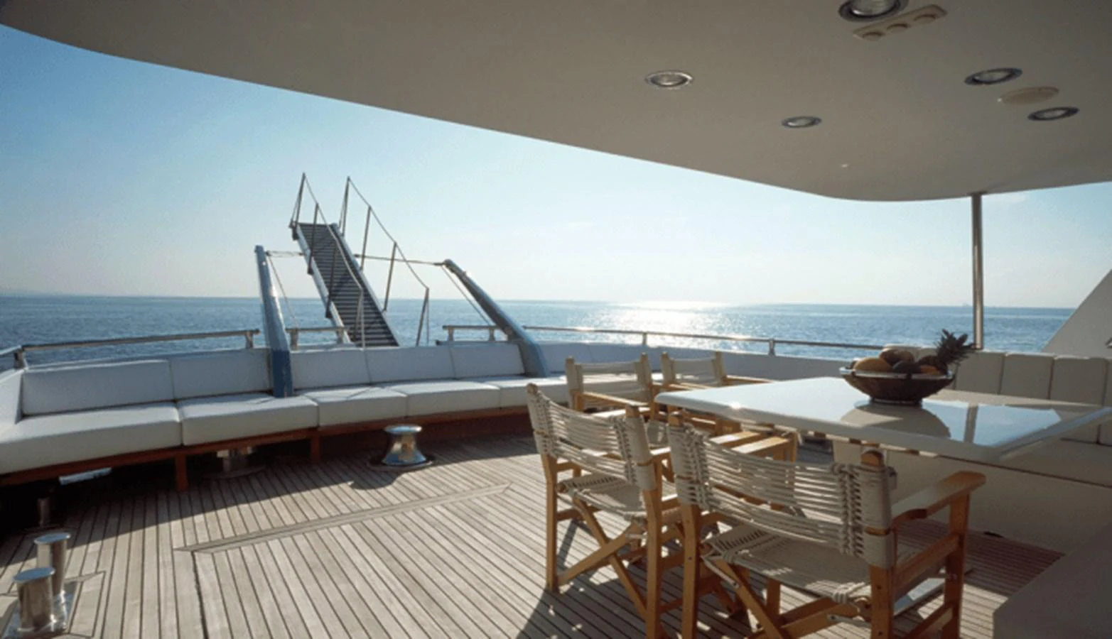 a deck with a view of the ocean and a large boat aboard ALLAHOU Yacht for Sale