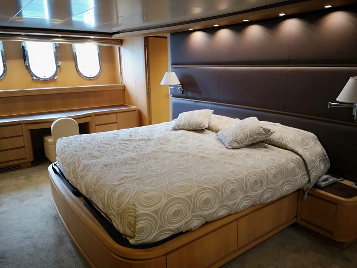 a bed with a white comforter aboard FIFTH AVENUE Yacht for Sale