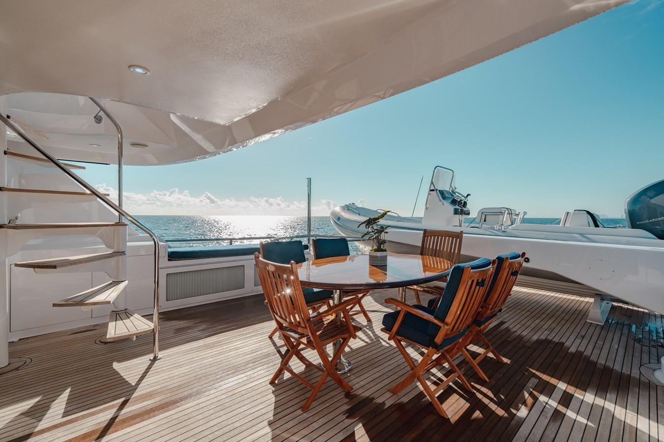 a deck with a table and chairs on it aboard FREE SPIRIT Yacht for Sale