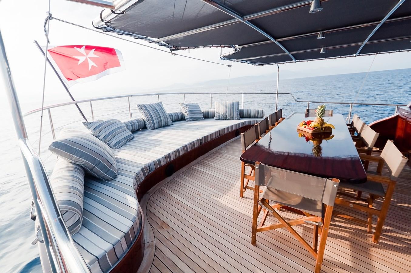 a boat with a table and chairs on the deck aboard VITA DOLCE Yacht for Sale