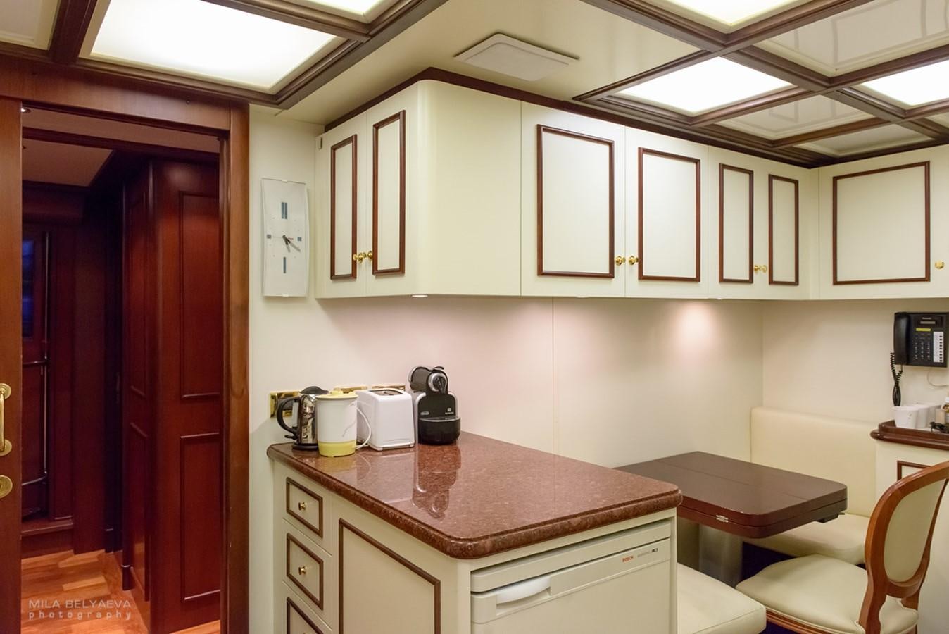 a kitchen with white cabinets aboard GIHRAMAR Yacht for Sale