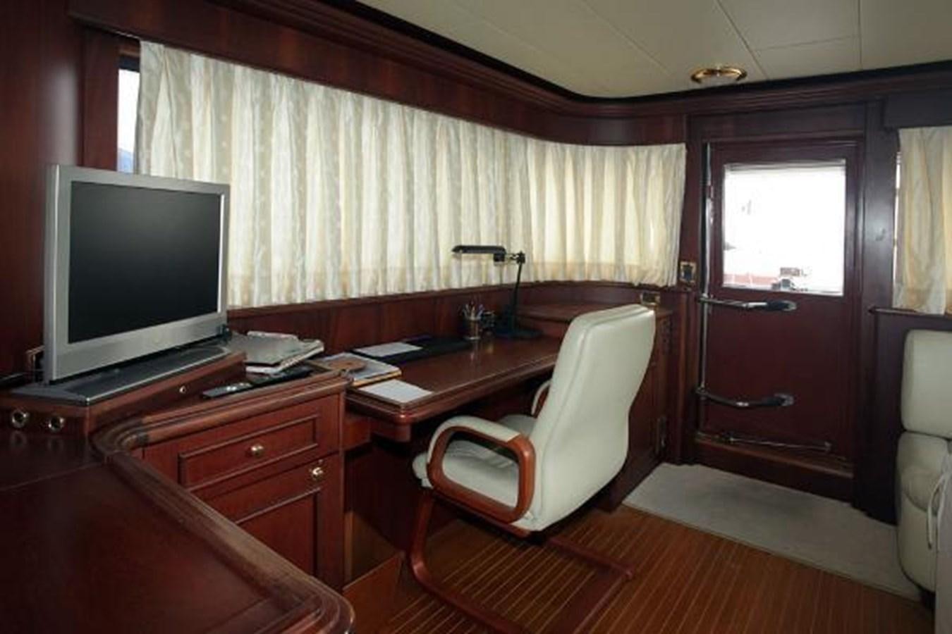 a living room with a tv and desk aboard GIHRAMAR Yacht for Sale