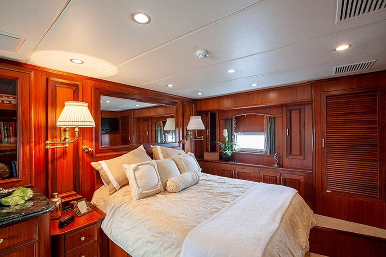 a bedroom with a bed and a lamp aboard RHAPSODY Yacht for Sale
