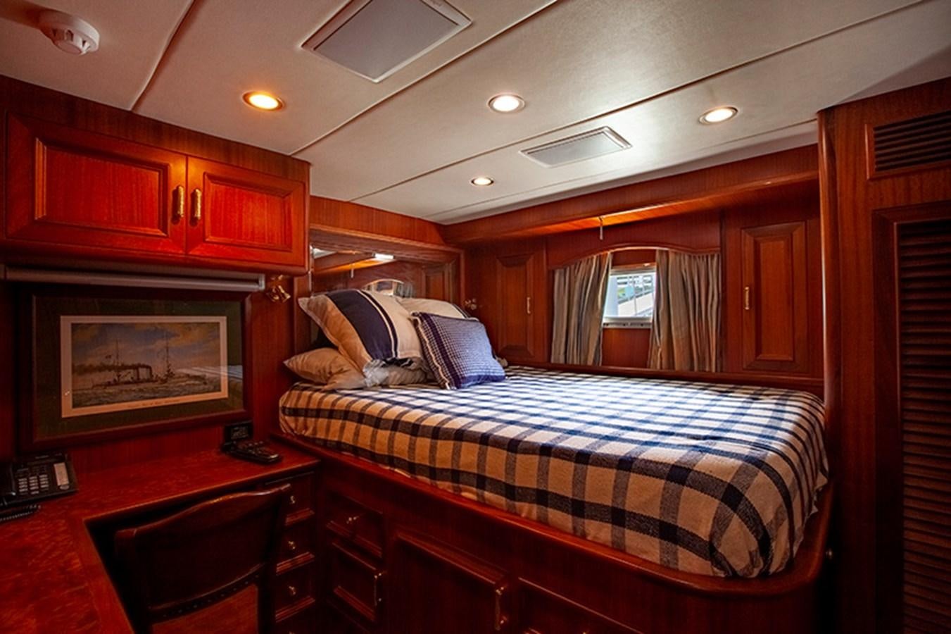 a bedroom with a bed and a television aboard RHAPSODY Yacht for Sale