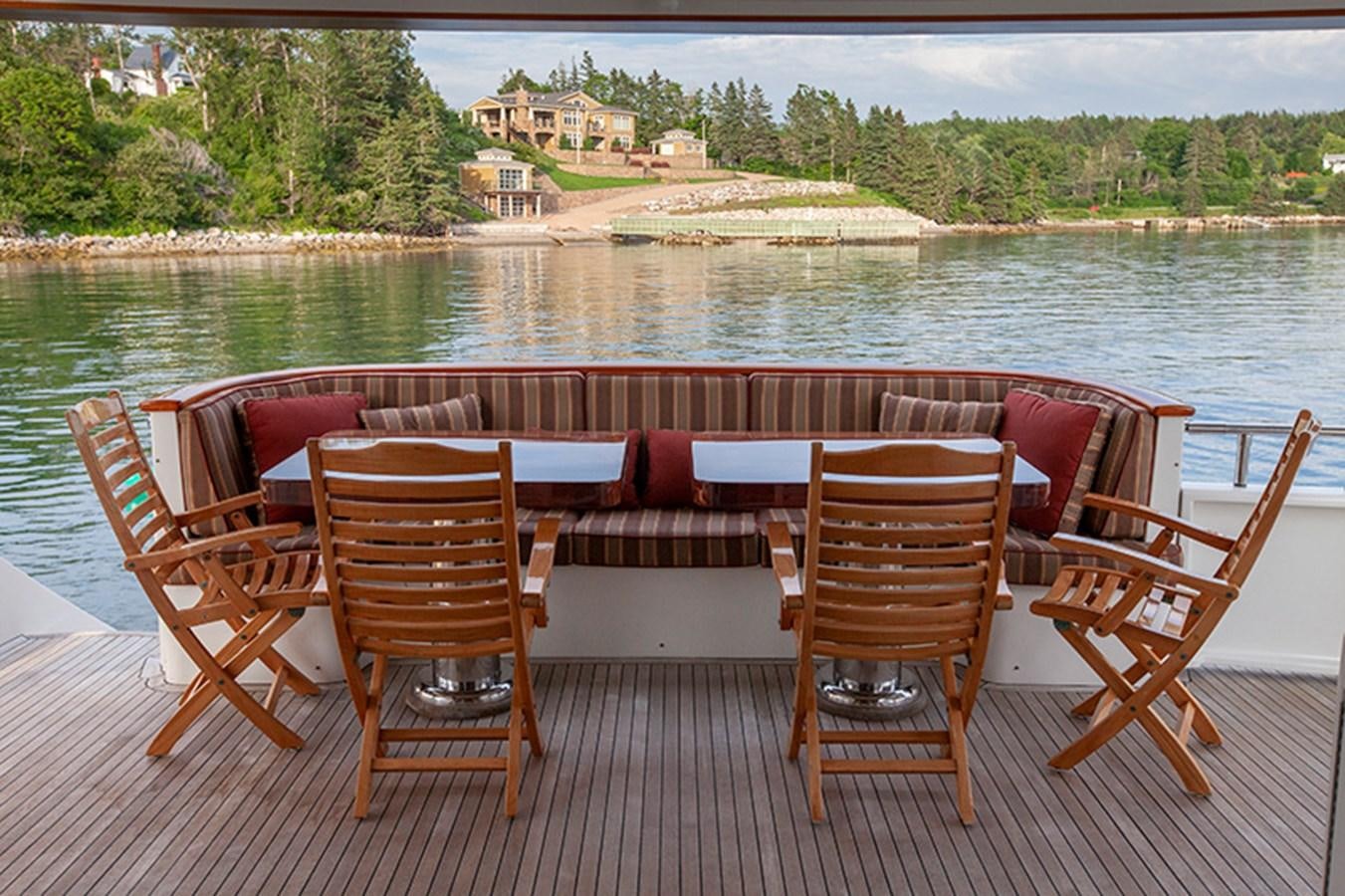 a group of chairs on a deck overlooking a lake aboard RHAPSODY Yacht for Sale