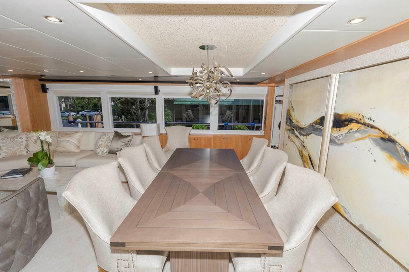 a large living room with a large table and couches aboard DUMB ASS Yacht for Sale