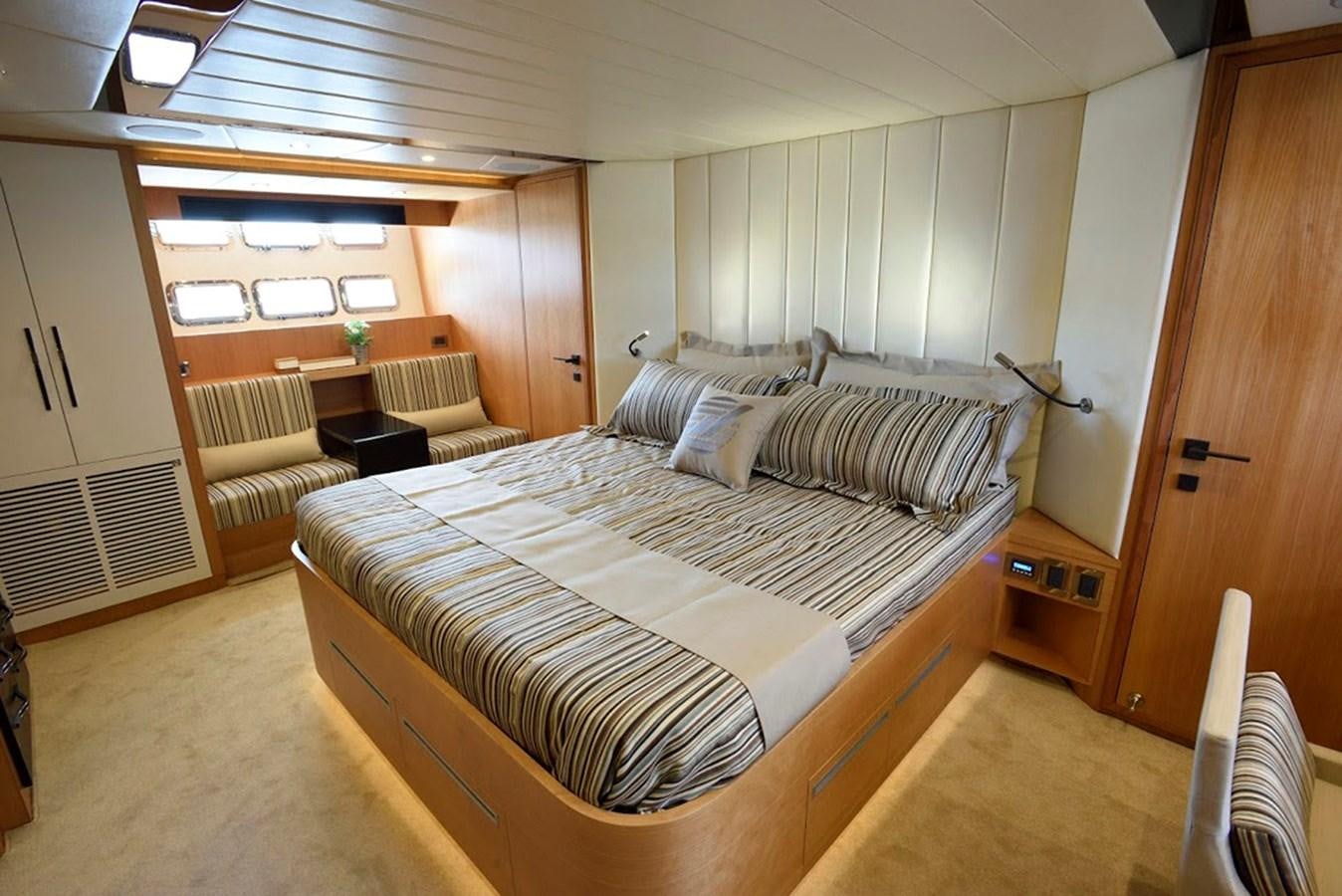 a room with a bed and a chair aboard DUMB ASS Yacht for Sale