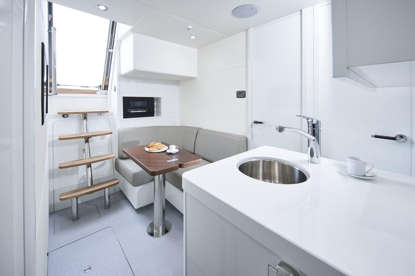 a kitchen with a table and a sink aboard PRINCESS Y85/504 Yacht for Sale