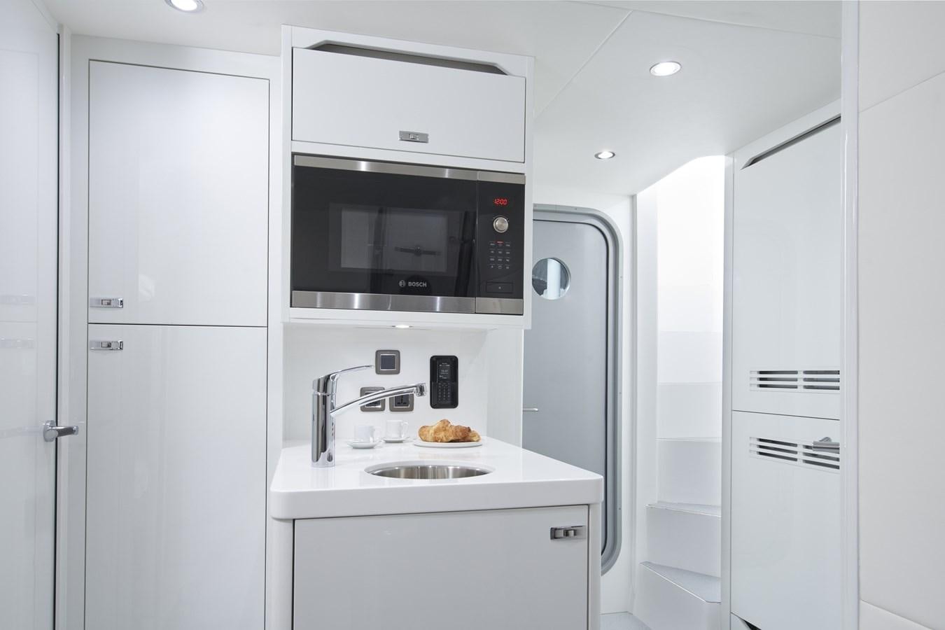 a kitchen with white cabinets aboard PRINCESS Y85/504 Yacht for Sale