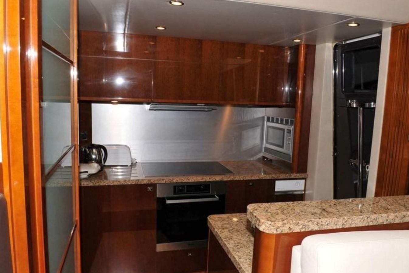 a kitchen with wooden cabinets aboard PRINCESS 85MY Yacht for Sale