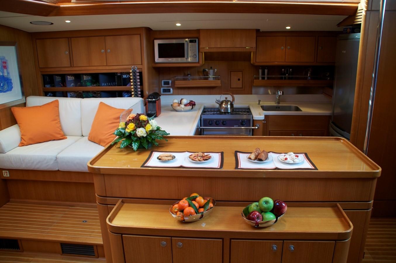 a kitchen with a table and a couch aboard VOLADOR Yacht for Sale