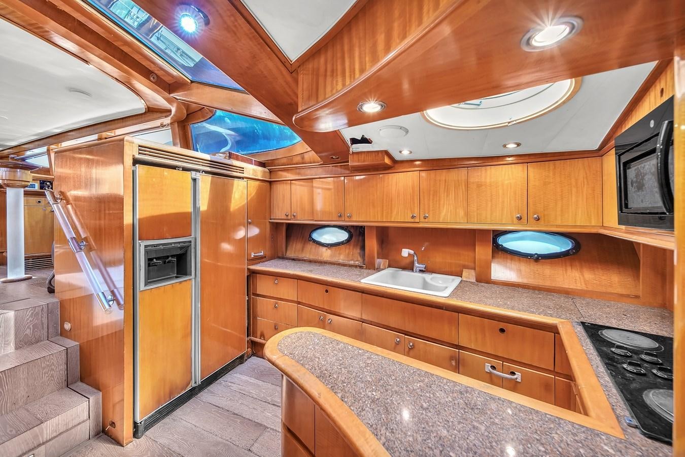 a kitchen with wooden cabinets aboard ZOOOM Yacht for Sale