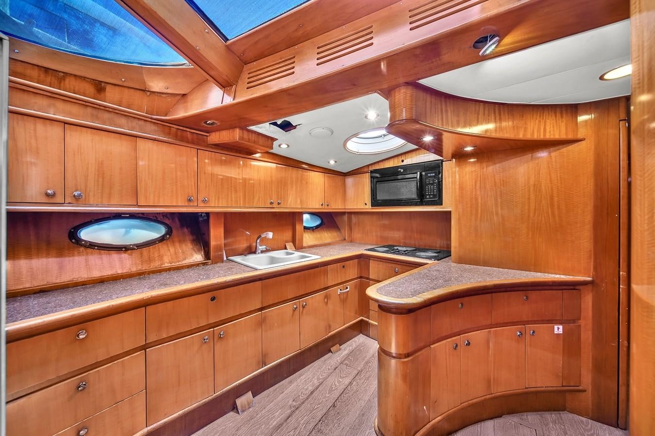 a kitchen with wooden cabinets aboard ZOOOM Yacht for Sale
