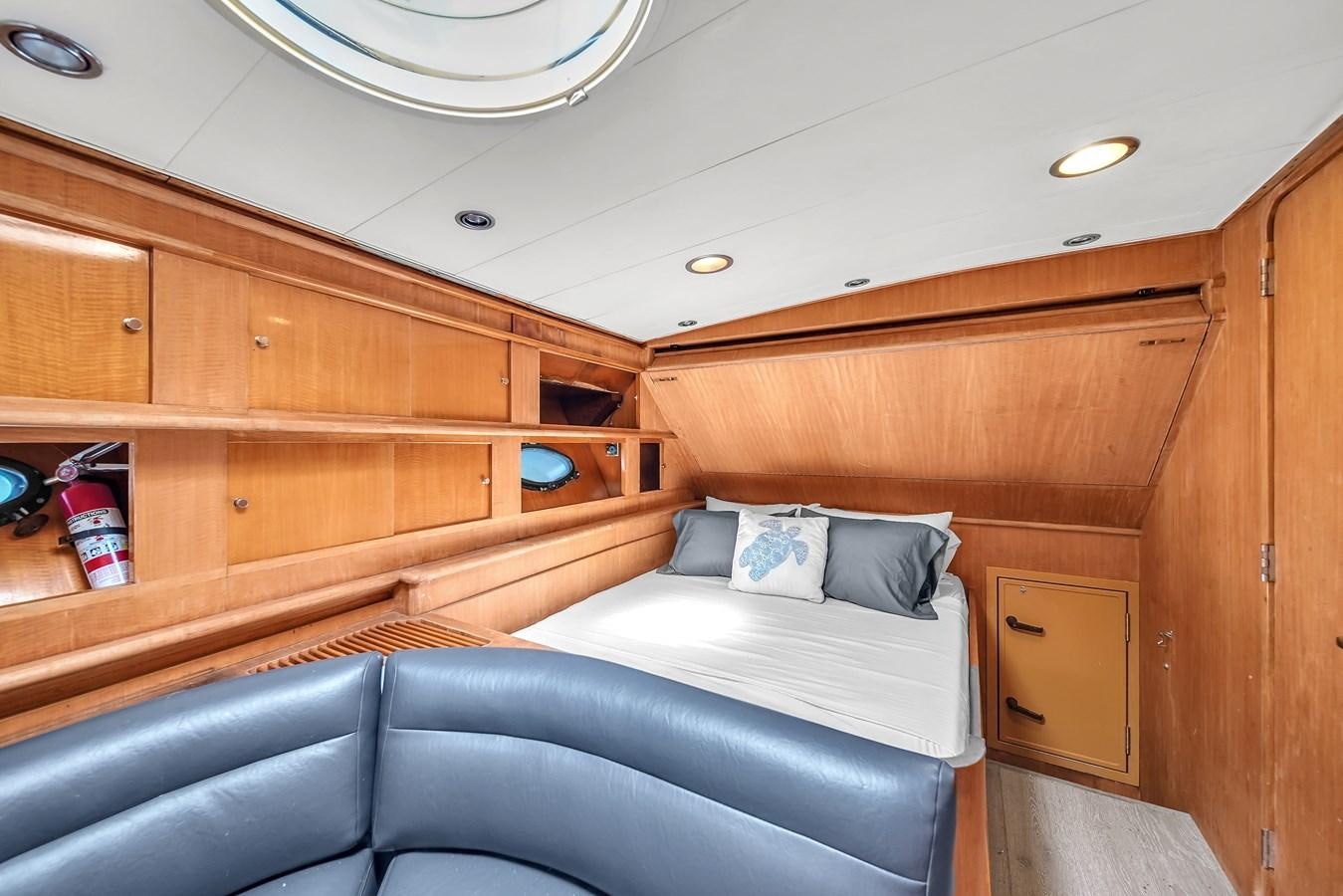 a room with a bed and a wood cabinet aboard ZOOOM Yacht for Sale