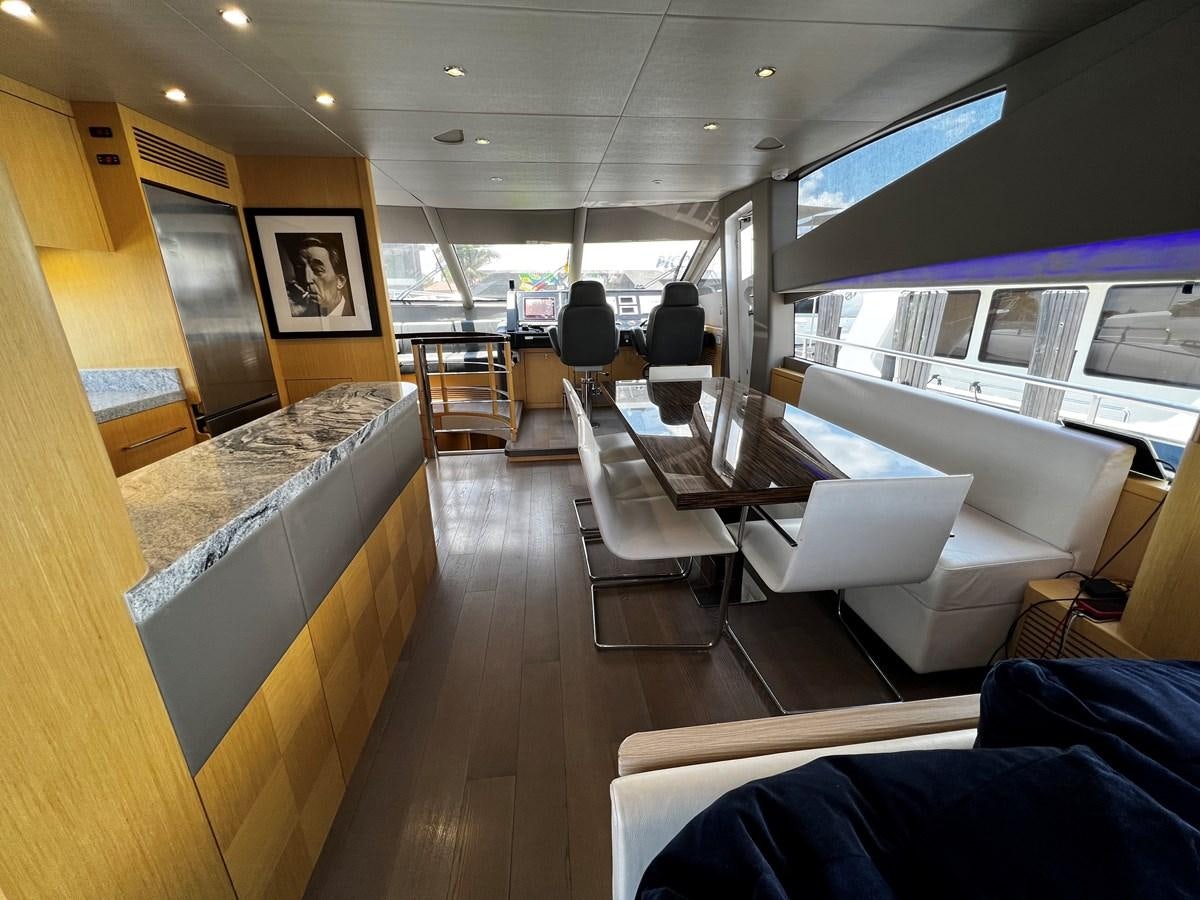 a room with a large table and chairs aboard MOJO RISIN Yacht for Sale