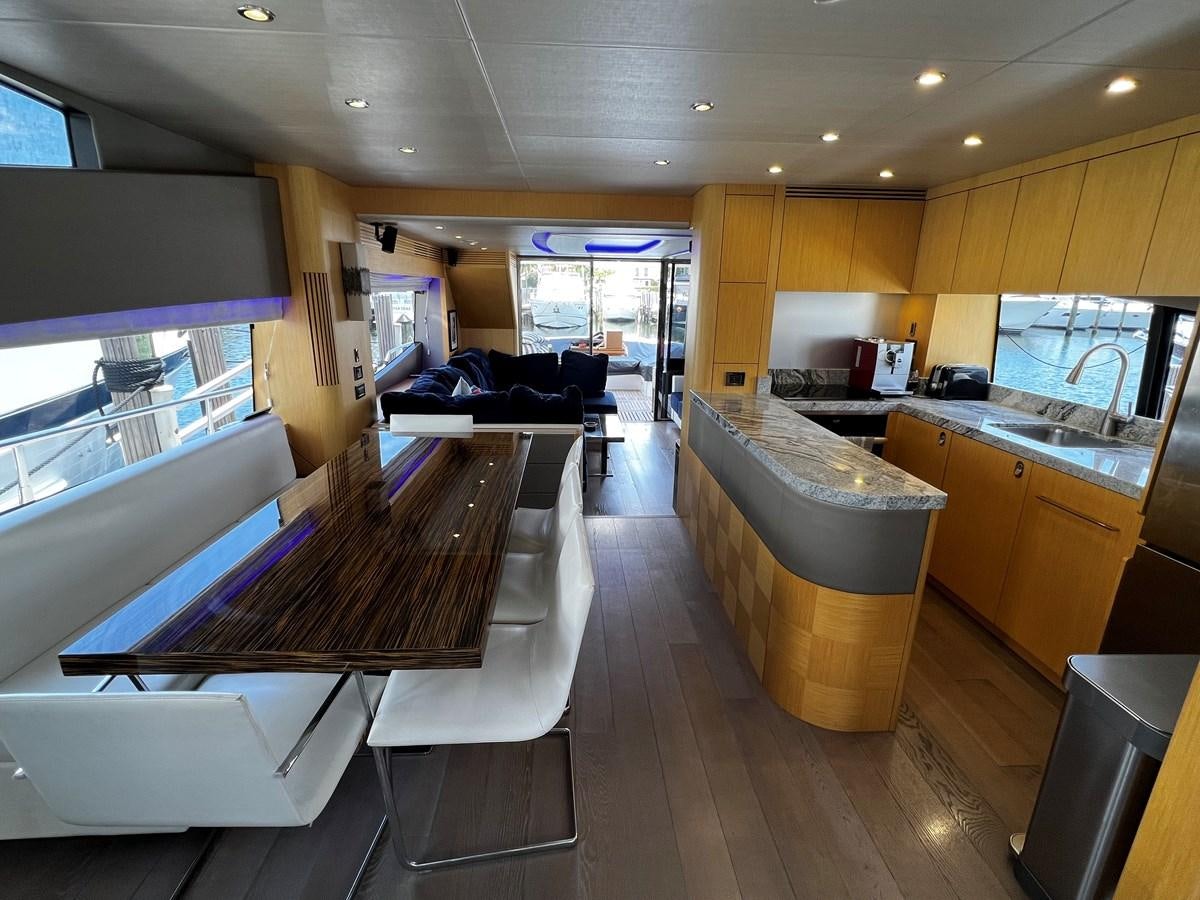 a kitchen with a bar and a table aboard MOJO RISIN Yacht for Sale