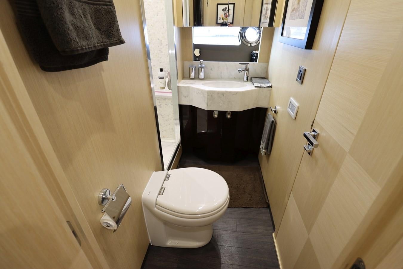 a small bathroom with a toilet sink and a mirror aboard MOJO RISIN Yacht for Sale