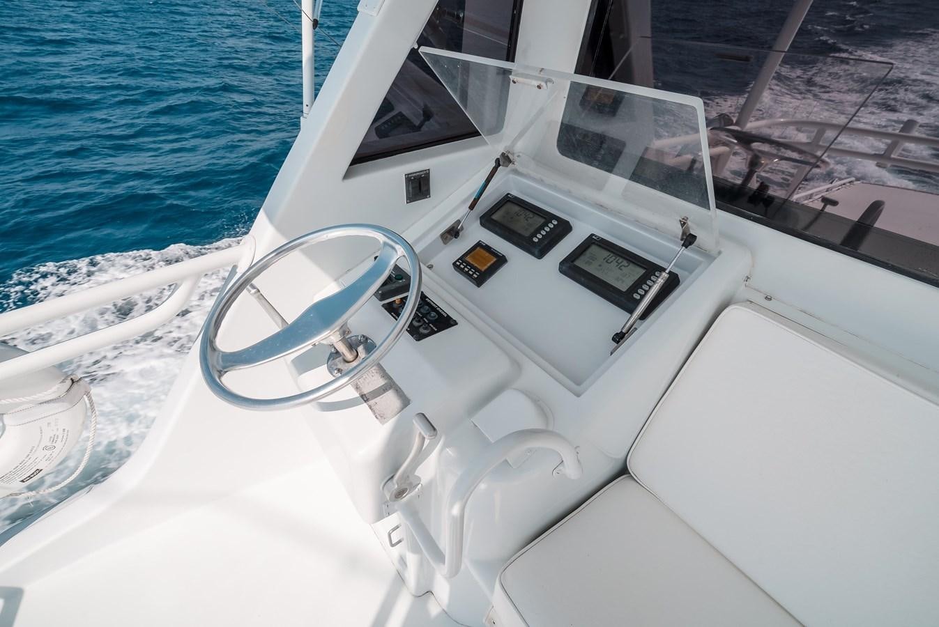 a white boat with a steering wheel aboard JUST LIKE THAT Yacht for Sale