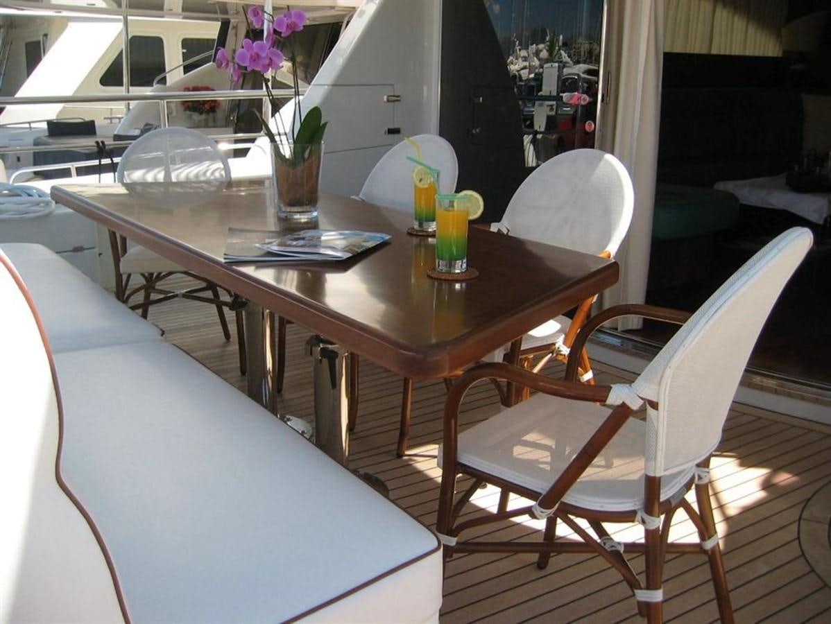 a table with chairs and a vase of flowers on it aboard CACAO BAY Yacht for Sale