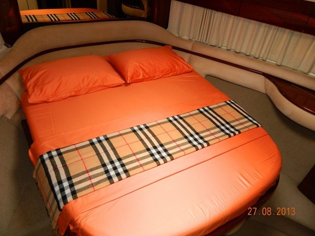 a bed with a red and white pillow aboard LOUISE Yacht for Sale