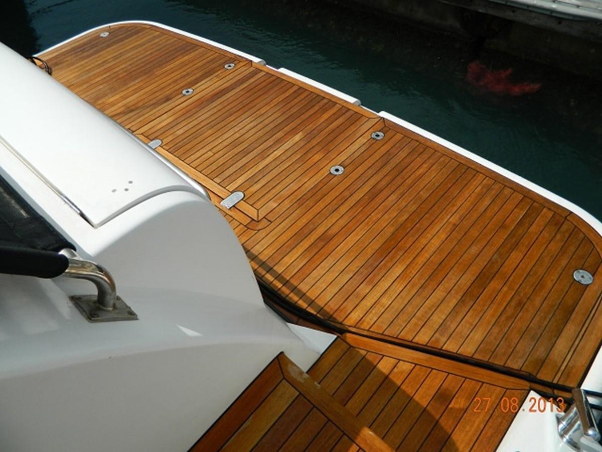 a wooden boat on a deck aboard LOUISE Yacht for Sale