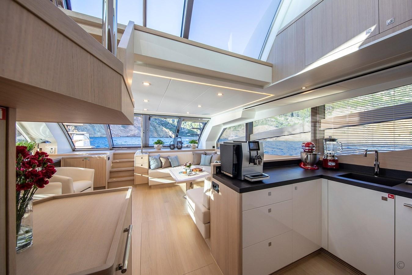 a kitchen with a microwave oven and a table aboard VAN DER VALK BEACHCLUB 660 FLYBRIDGE Yacht for Sale