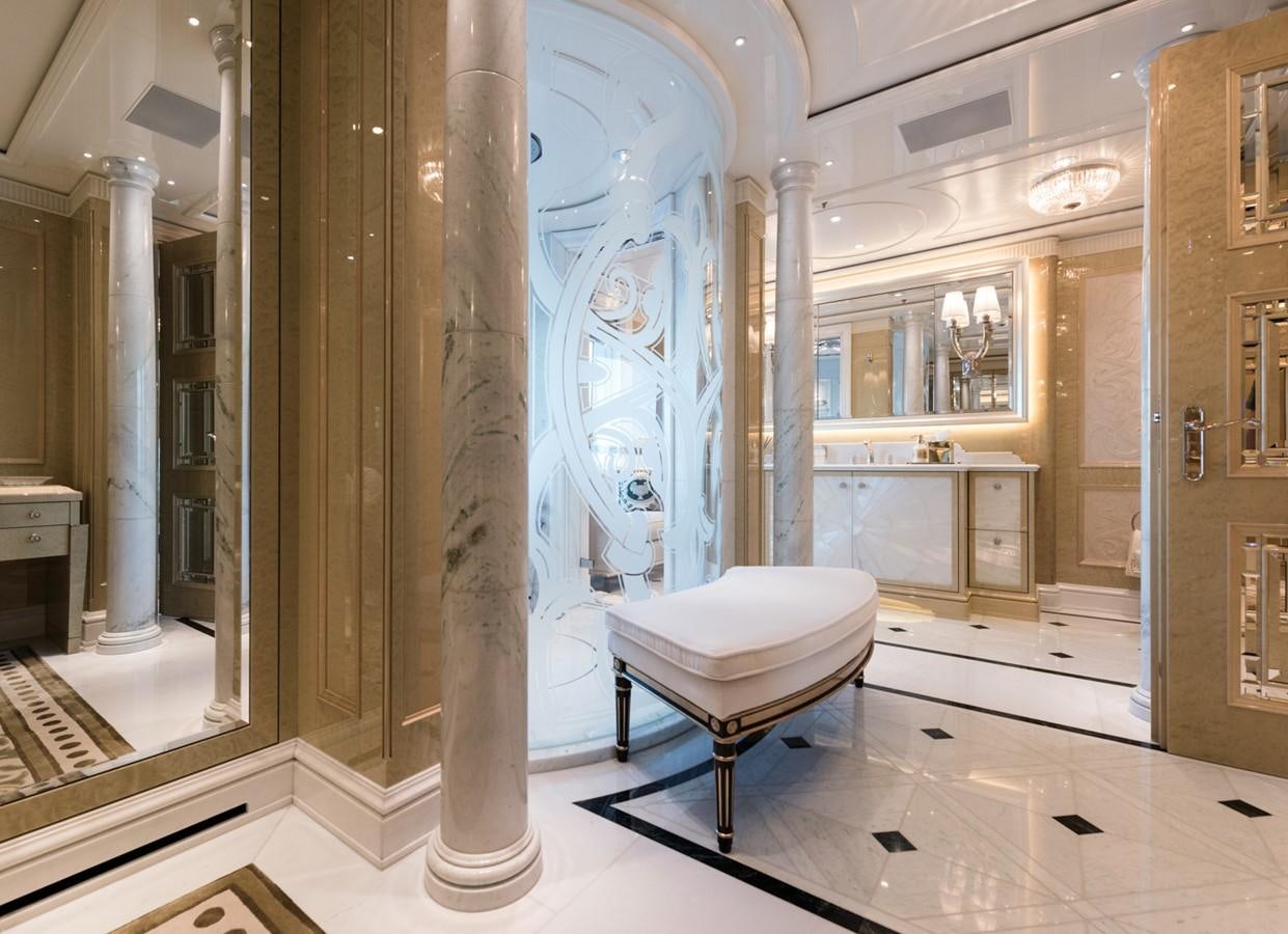 a room with a white chair and a large pillar with columns aboard PLVS VLTRA Yacht for Sale