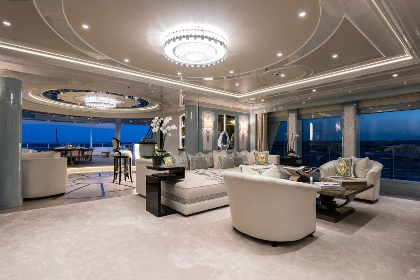 a large room with couches and a large window aboard PLVS VLTRA Yacht for Sale