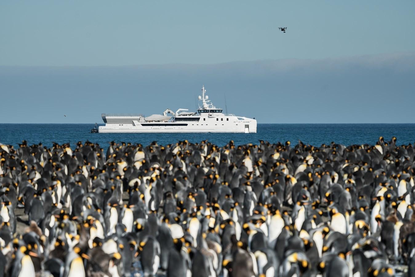 a large group of people standing in front of a boat in the water aboard GAME CHANGER Yacht for Sale