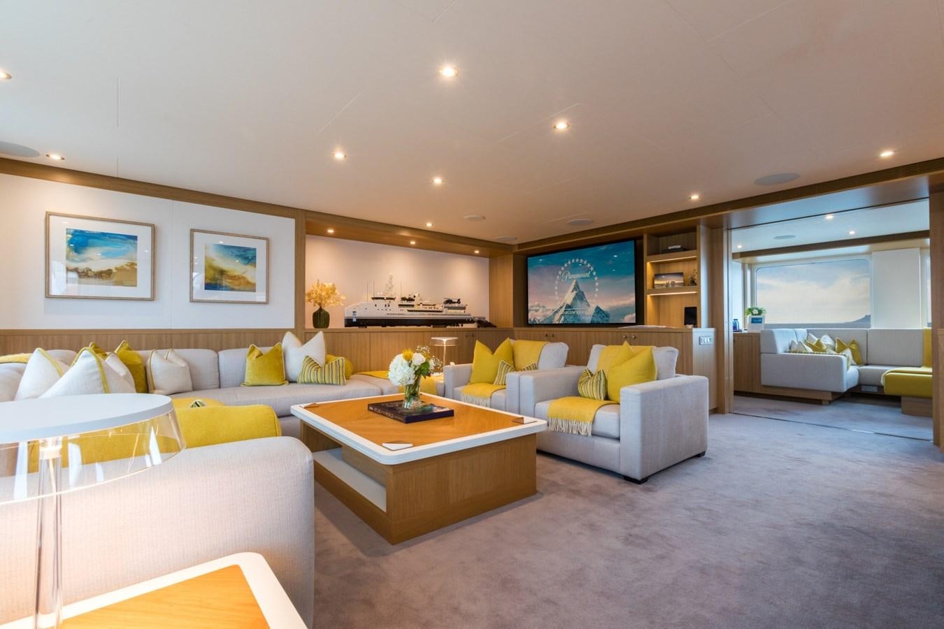 a living room with a table and couches aboard GAME CHANGER Yacht for Sale