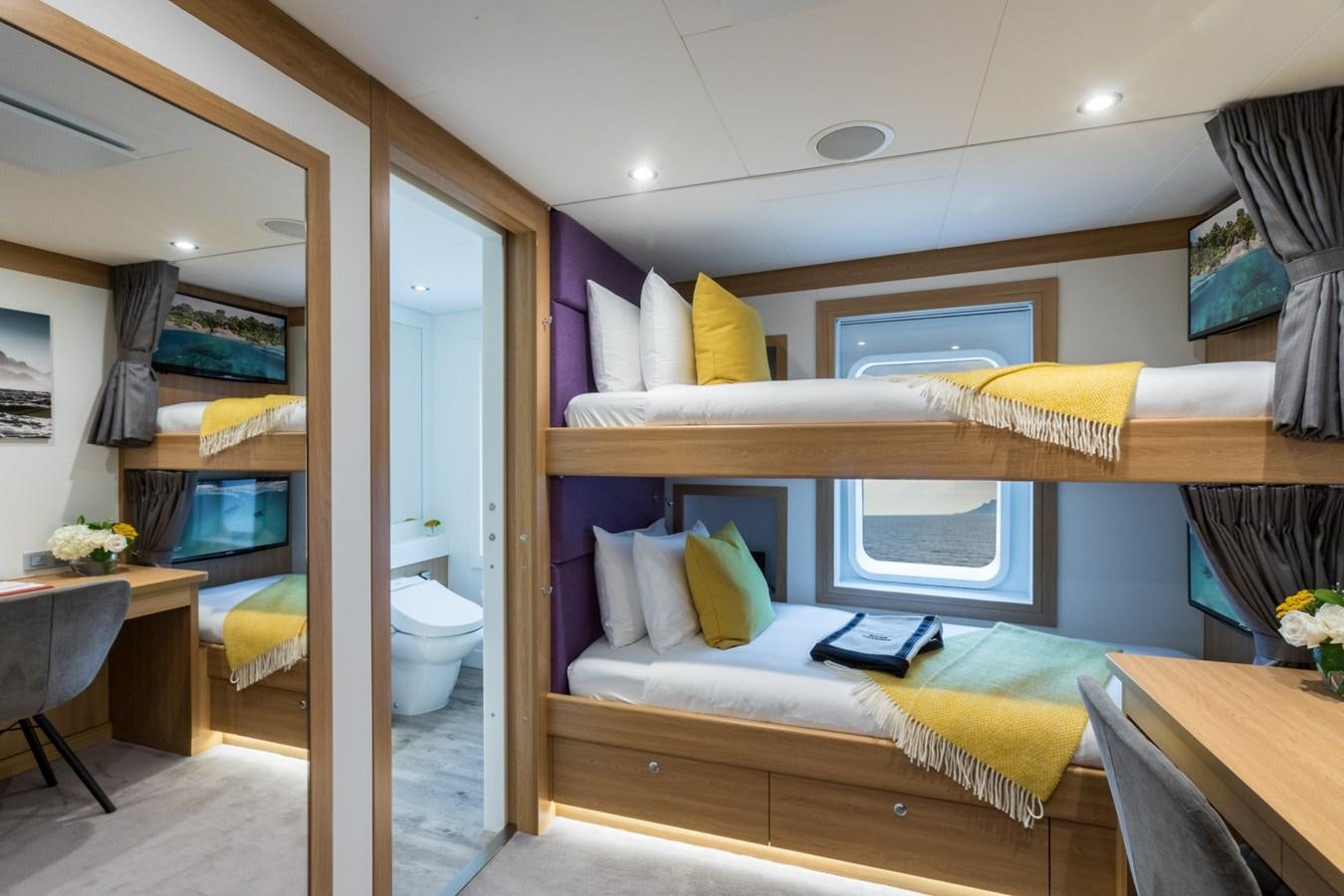 a bedroom with a bed and a desk aboard GAME CHANGER Yacht for Sale