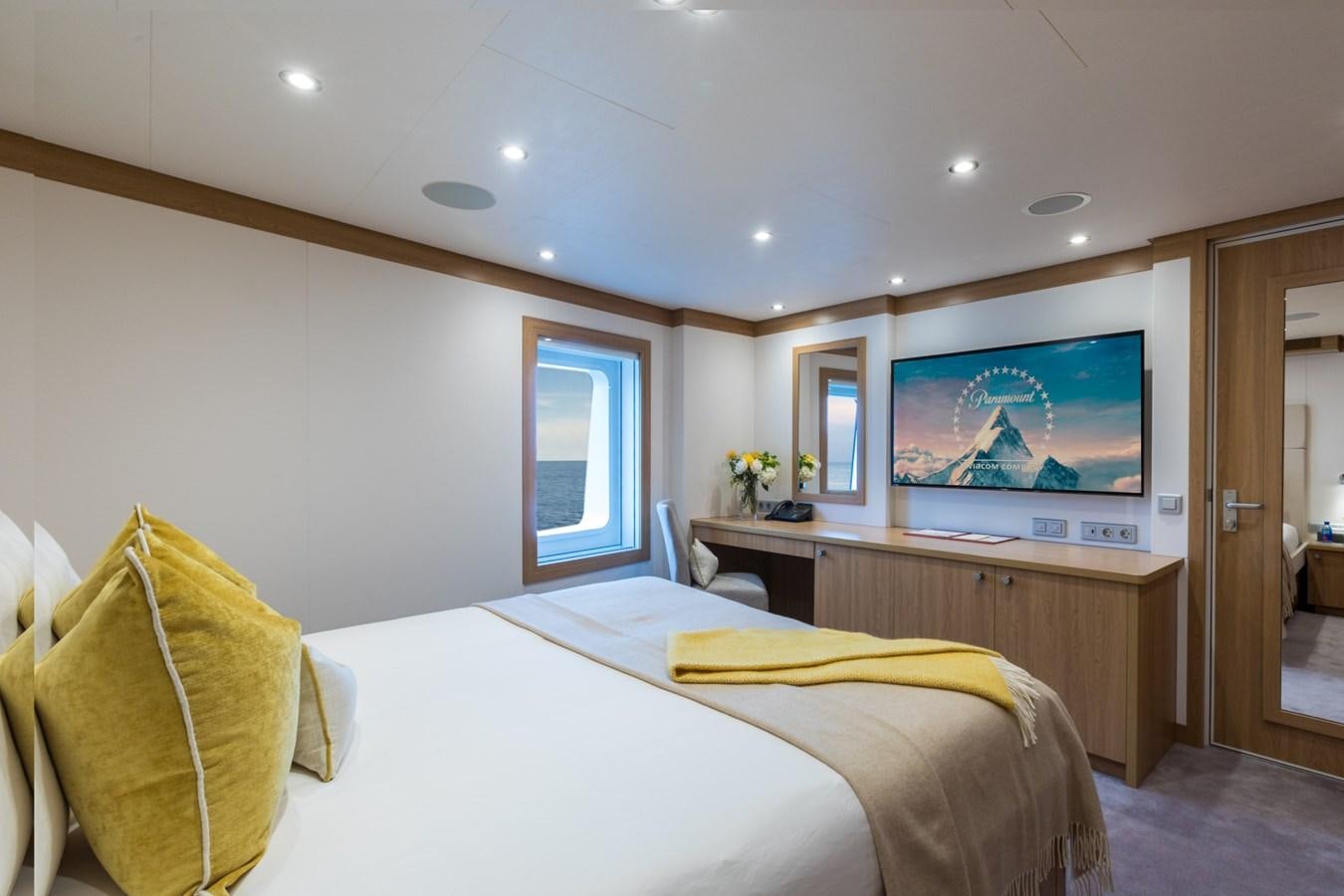 a bedroom with a tv on the wall aboard GAME CHANGER Yacht for Sale